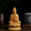 Front view of a boxwood Guanyin seated on a lotus pedestal with a slender water vase