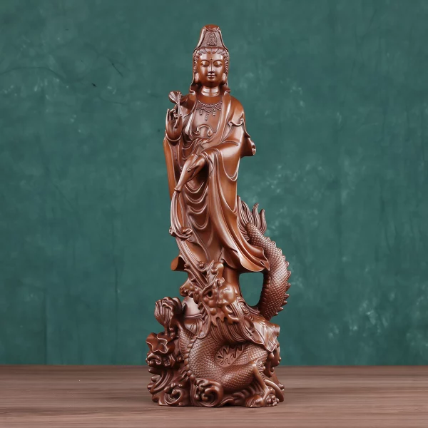 Front of a copper Guanyin standing above a coiling dragon, holding a leafy sprig and a lowered vase