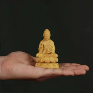 Natural boxwood Guanyin, 8 cm high, shown on a hand for scale
