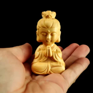 A 7 cm Hezhang Kuan Yin figurine resting in an open hand to show its small scale A 7 cm Hezhang Kuan Yin figurine resting in an open hand to show its small scale