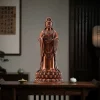 Copper Putuo Kuan Yin on an indoor console, with framed artwork and vessels in the background