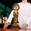 Standing brass Guanyin displayed beside a person’s hands for a sense of its 45 cm scale