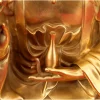 Close view of the slender vase resting upright in the left palm of the 38 cm brass Kuan Yin