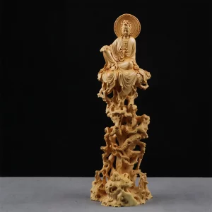 Front view of the 20 cm small-leaf boxwood Guanyin sitting above an openwork rock formation