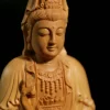 Close view of the lowered eyes, lips and chest ornament of the boxwood Kuan Yin