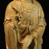 Guanyin’s hand holding a leafy sprig beside the tilted water vase