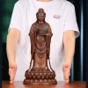 The 38 cm copper Putuo Kuan Yin on a table in front of an adult for scale