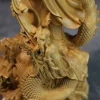 Carved stream above the dragon head and overlapping scales in the natural wood finish