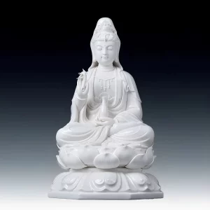 White porcelain Bajiaozuo Guanyin statue holding a vase and sprig, seated on a lotus above an octagonal pedestal