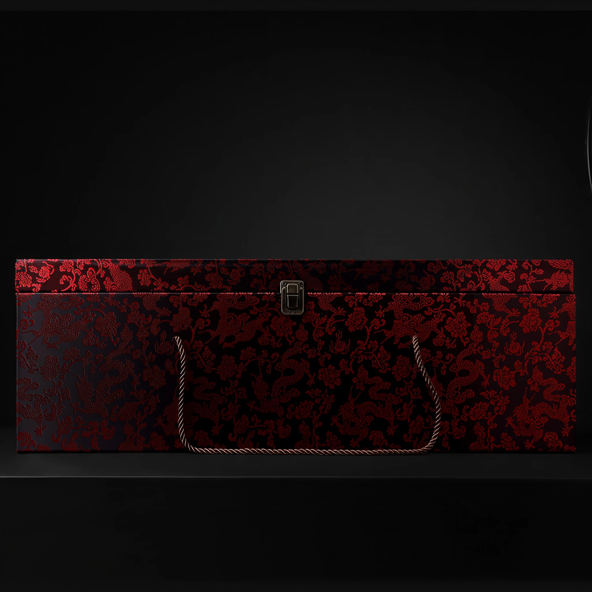 Red and black patterned presentation box with rope handles shown by the supplier for Bajiaozuo Guanyin