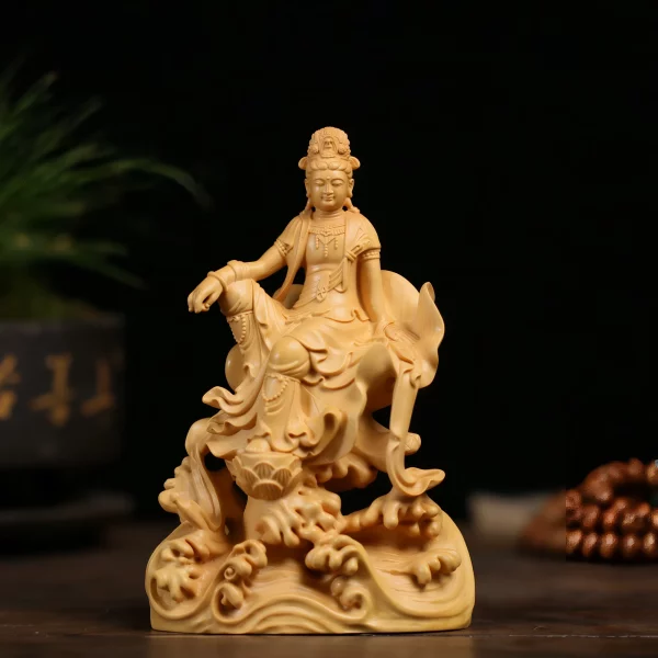 Front view of the golden boxwood Guanyin at ease, with one knee raised and a lotus blossom above curling waves