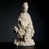 Opposite side of the Chijing Guanyin statue showing the raised knee, bare foot and sculpted rock base