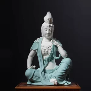 Front view of the contemplative Guanyin statue with one knee raised, a lifted hand and textured teal robes, 33 cm (13.0 in) tall