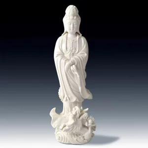 Full front view of the glazed white Dragon Guanyin statue, with crossed hands and a lotus leaf above a dragon and waves