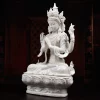 Three-quarter view of the white Four-Armed Guanyin with a tall crown, raised lotus and rounded pedestal