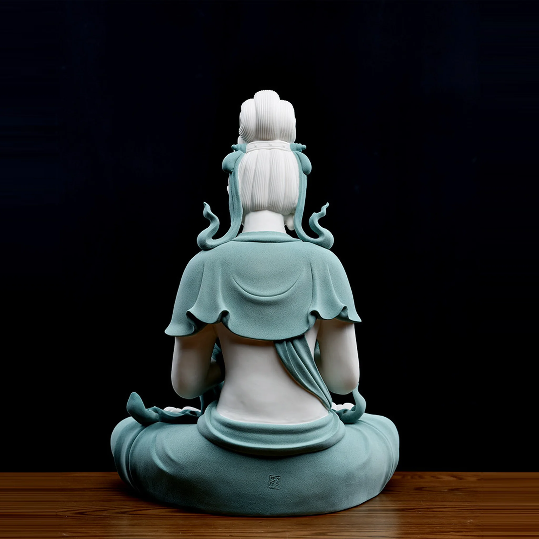 Back view of the teal Hezhang Guanyin statue showing sculpted hair, curling ribbons and an impressed mark