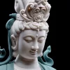 Close-up of Hezhang Kuan Yin’s lowered eyes, softly smiling face and raised crown ornaments