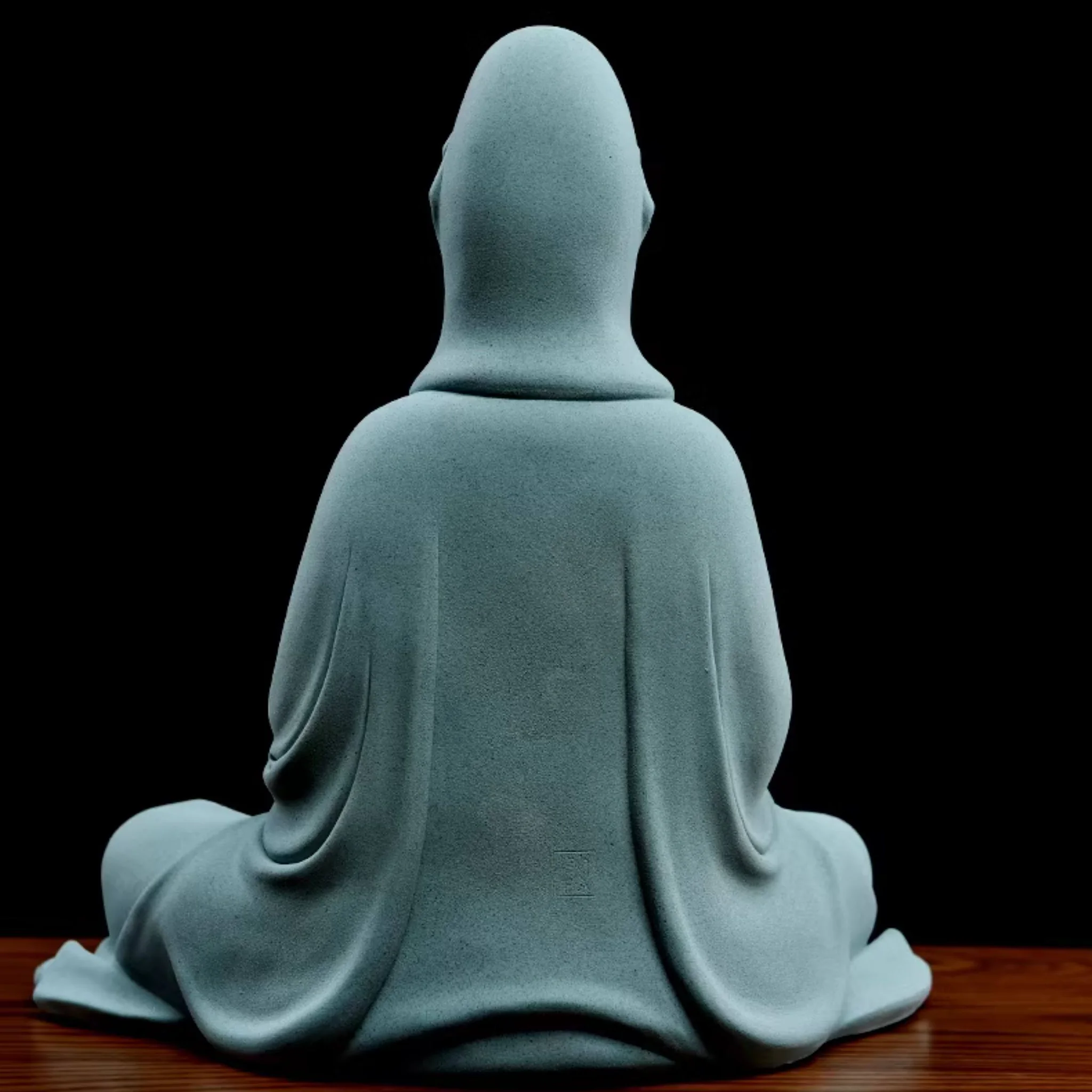 Back of the teal Jingsi Kuan Yin statue, showing the hood, long robe folds and a faint impressed mark