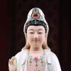 Linghui Kuan Yin’s softly smiling face, dark hair and white hood with a small painted Buddha in the crown