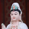 Face and crown detail of a painted porcelain Guanyin statue showing painted face, white veil and turquoise-colored crown details