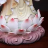 Lotus base and robes detail of a painted porcelain Guanyin statue showing pink-tipped lotus petals, scrolling pedestal and warm-toned robe folds