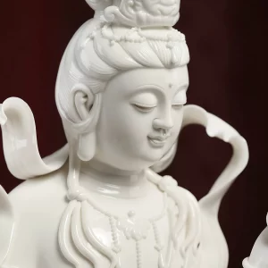 Lotus Ribbon Guanyin — Face and crown detail Close-up of Piaodai Kuan Yin’s lowered eyes, small smile, crown and necklace in glazed white porcelain