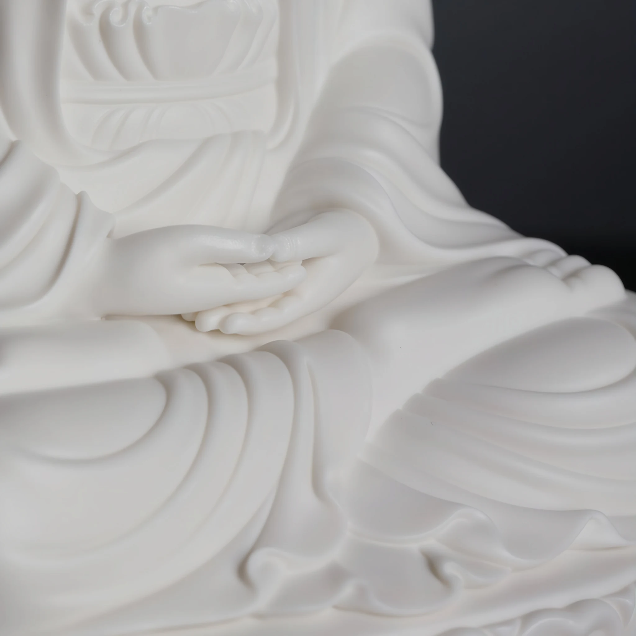 Hands resting one above the other across the lap, surrounded by robe folds on the 22 cm (8.7 in) Pilu Guanyin statue in white porcelain
