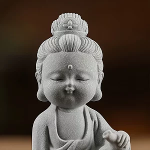 Mini Jingping Guanyin — Rounded face and crown · frontal detail Small Kuan Yin figurine detail showing rounded cheeks, closed eyes, crown and robe folds