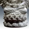 Layered lotus petals and curling relief below the crossed legs of the Thousand-Armed Guanyin
