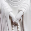 Unglazed white hands and prayer beads on the three-faced Kuan Yin sculpture