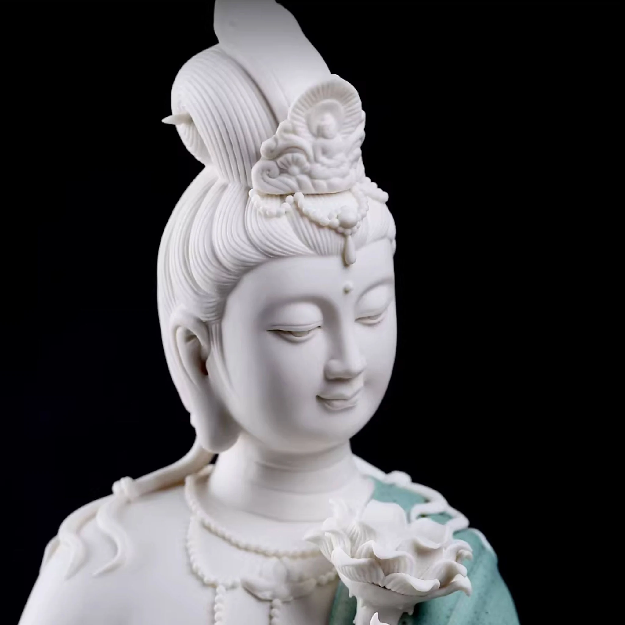 Close-up of the Water Moon Guanyin statue’s face, crown and white veil against teal robes