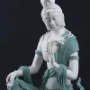 Three-quarter close-up of the teal and white Water Moon Guanyin statue with a raised knee and draped robes