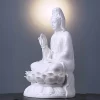 Three-quarter view of the 29 cm (11.4 in) Pure White porcelain Guanyin statue, showing the raised hand, vase and layered lotus petals.