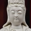 Close view of the Willow Guanyin face, lowered eyes, small smile and lower crown in glossy white ceramic
