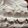 Ribbed lotus petals beneath the seated Willow Guanyin, above waves and rounded relief on the pedestal
