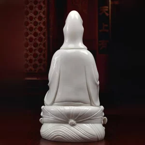 Back of the white Yangzhi Guanyin statue, showing long robe folds and the tied motif above the wave relief