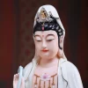 Face and crown detail of the 30 cm Xiangyun Guanyin, with painted eyes, black hair, a small seated crown figure and pink necklace detail