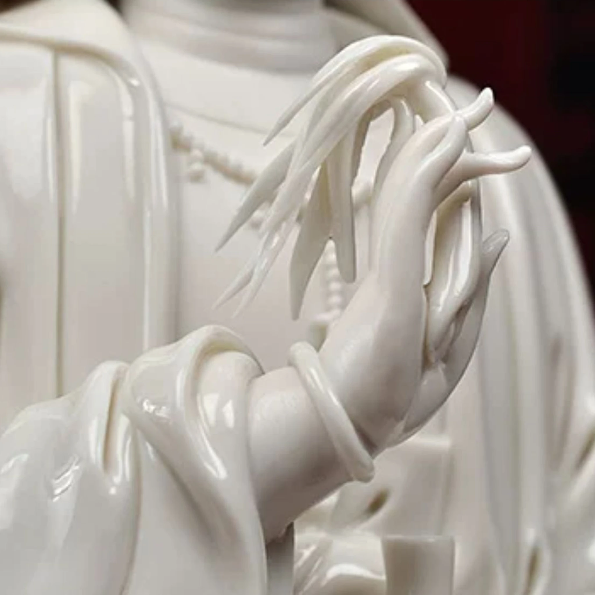 Raised hand of the Yangzhi Guanyin statue holding the narrow leaves of a willow sprig