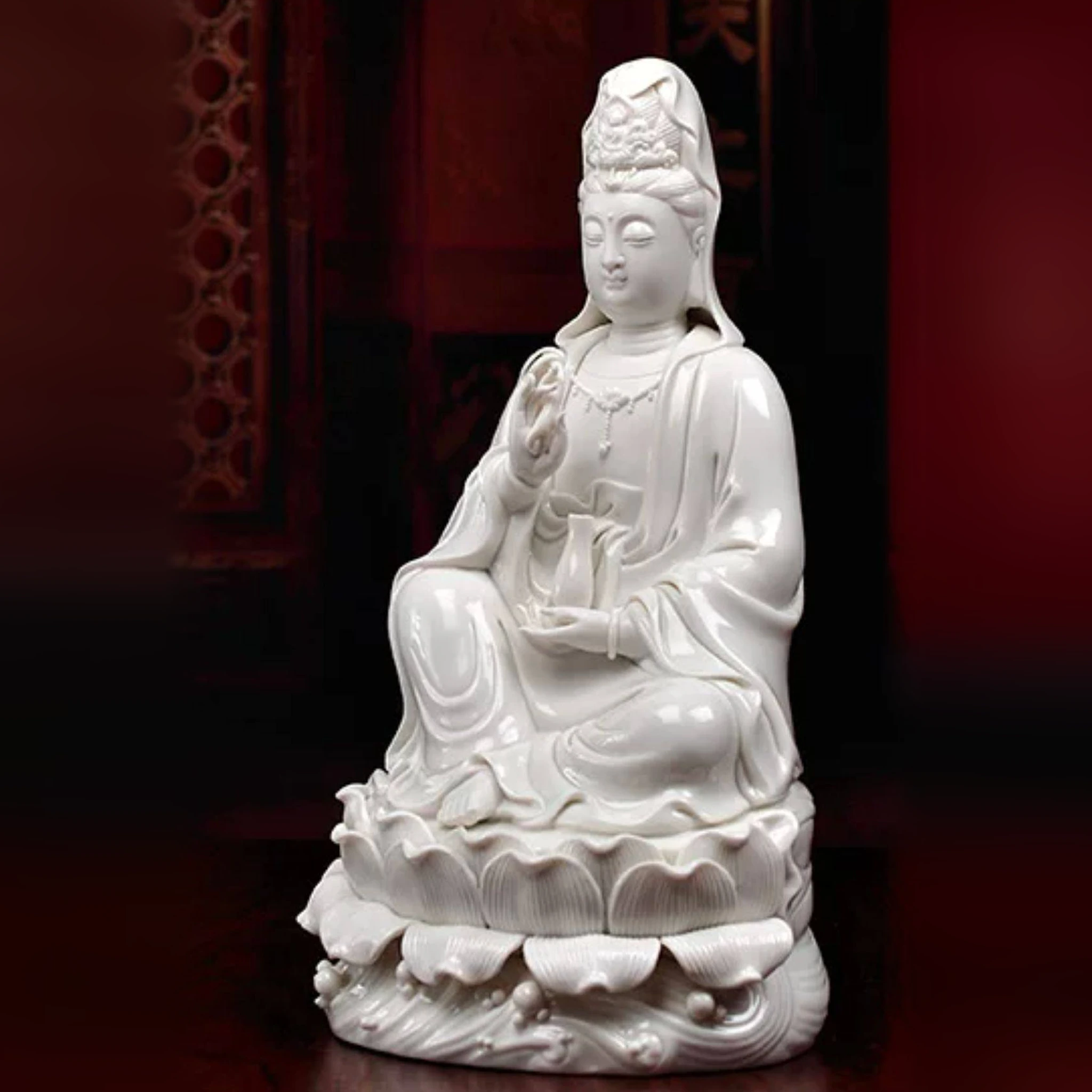 Three-quarter view of the seated Yangliu Kuan Yin statue with a raised knee, willow branch, vase and layered lotus pedestal