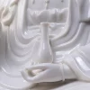Slender vase held above the open palm of the white Zuolian Guanyin statue