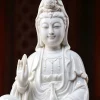 Close view of Zuolian Kuan Yin showing the face, crown figure, raised hand and vase